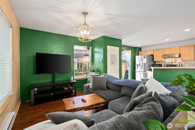 living area with wood finished floors, baseboards, recessed lighting, a baseboard heating unit, and a chandelier