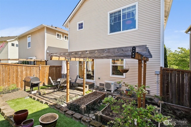 back of house with a garden, a pergola, a fenced backyard, a patio area, and a lawn