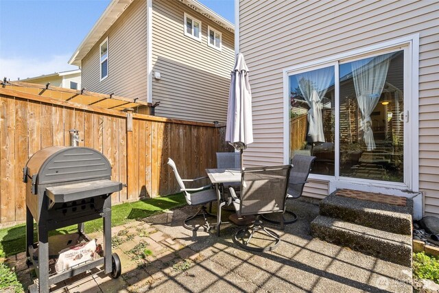 view of patio / terrace with area for grilling, fence, outdoor dining space, and entry steps