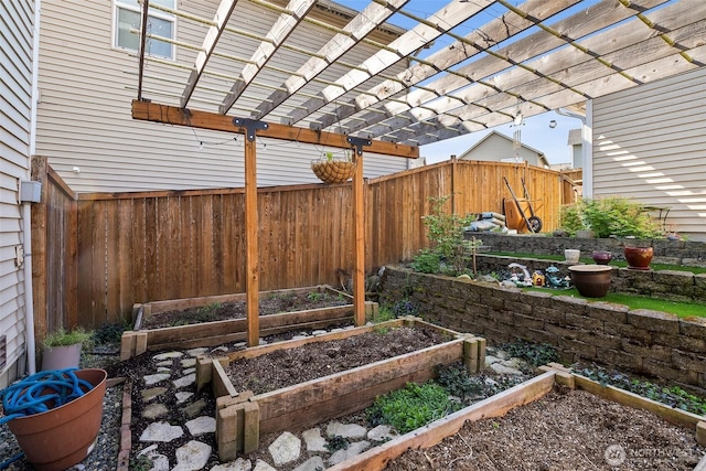 view of yard with fence, a pergola, and a garden