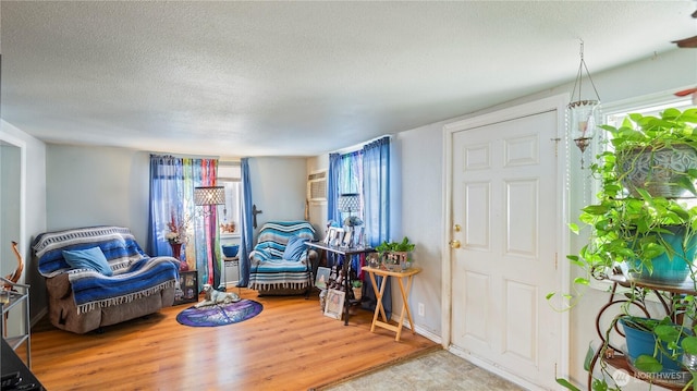 interior space with a textured ceiling and wood finished floors