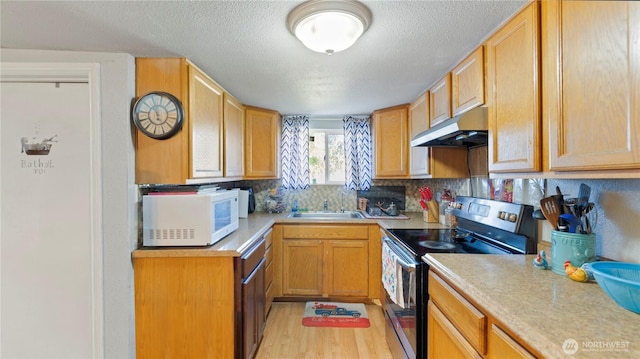kitchen featuring stainless steel range with electric cooktop, light countertops, a textured ceiling, white microwave, and under cabinet range hood