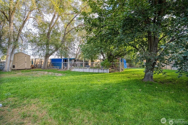 view of yard with a storage shed, fence, and an outbuilding