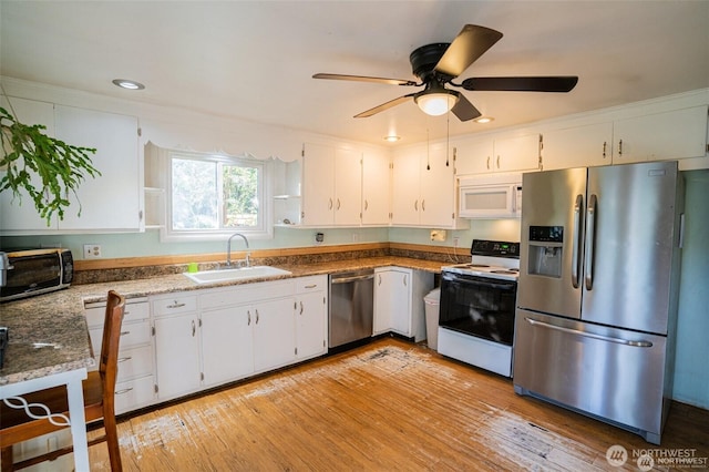 kitchen featuring white cabinets, appliances with stainless steel finishes, a sink, light wood finished floors, and a ceiling fan