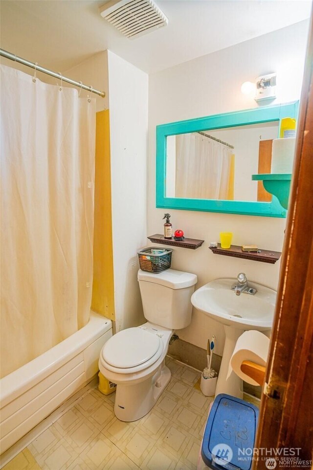 bathroom with visible vents, tile patterned floors, toilet, and shower / bath combo with shower curtain