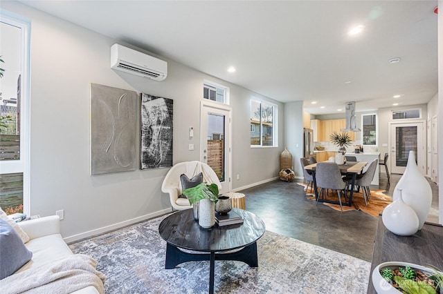 living room featuring concrete flooring, recessed lighting, baseboards, a wealth of natural light, and a wall mounted AC