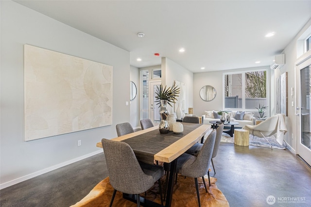 dining room with finished concrete floors, recessed lighting, baseboards, and an AC wall unit