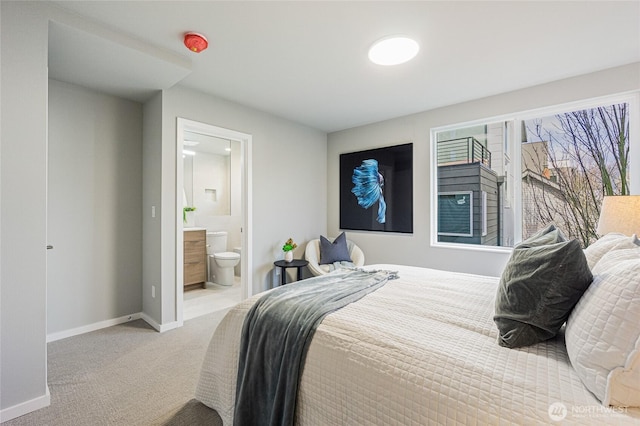 bedroom with carpet flooring, baseboards, and ensuite bath