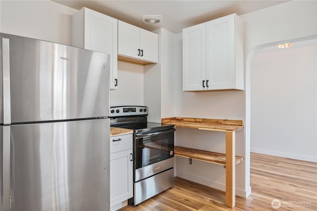 kitchen with stainless steel appliances, visible vents, white cabinetry, and light wood-style floors