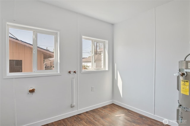 interior space with baseboards, wood finished floors, and water heater