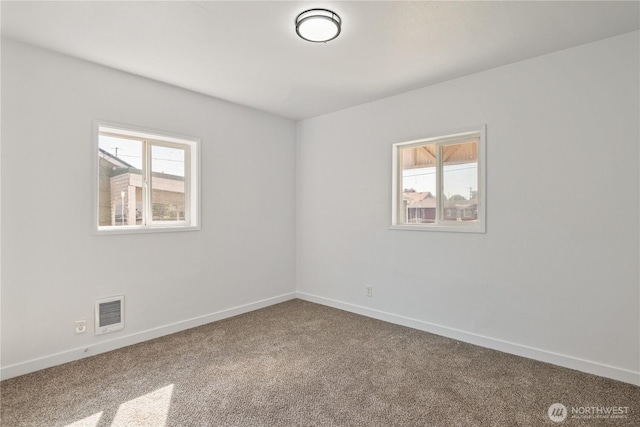 carpeted empty room featuring baseboards and visible vents