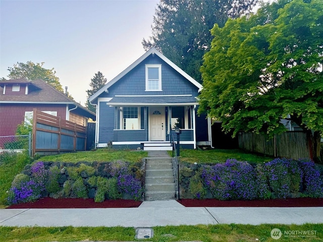 bungalow-style house featuring a porch and fence private yard