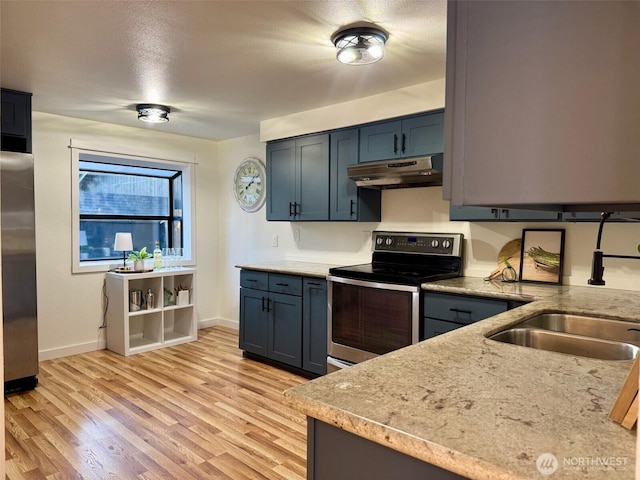 kitchen with a sink, baseboards, under cabinet range hood, light wood-style floors, and stainless steel appliances