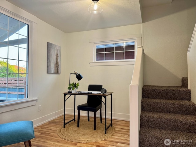 home office with baseboards, wood finished floors, and a wealth of natural light