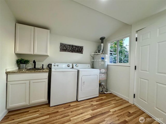laundry room featuring light wood-style floors, washer and clothes dryer, a sink, cabinet space, and water heater