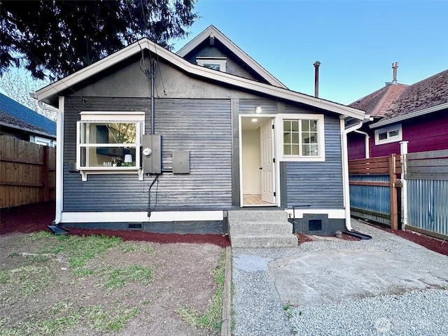 bungalow-style house with a patio, fence, crawl space, and entry steps