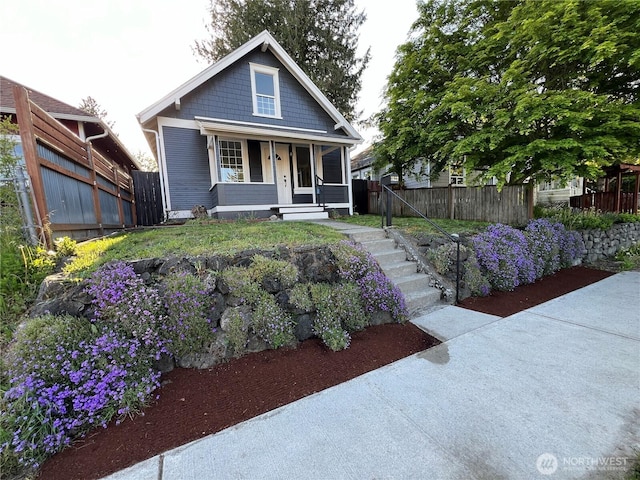 view of front of property featuring covered porch and fence