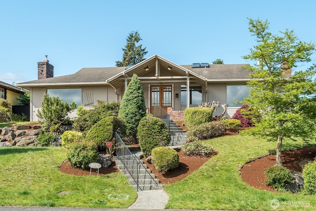 ranch-style home featuring french doors, a chimney, stairs, and a front yard