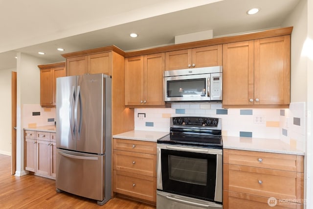 kitchen featuring light countertops, appliances with stainless steel finishes, and light wood-type flooring