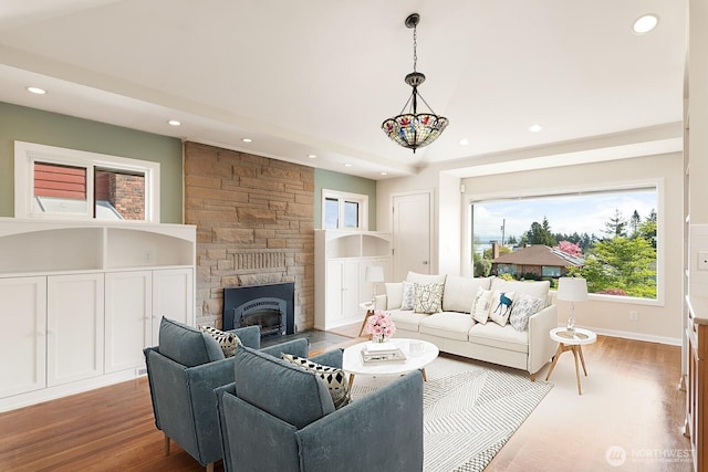 living area with recessed lighting, wood finished floors, and a fireplace