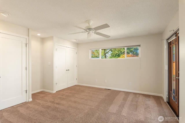 unfurnished bedroom with baseboards, carpet, a ceiling fan, and a textured ceiling