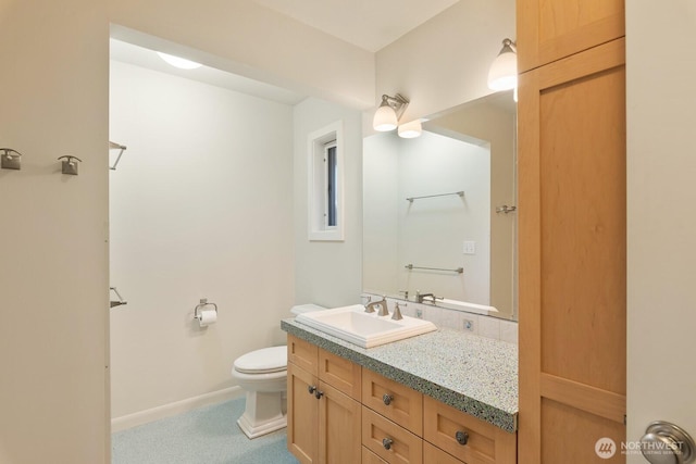 bathroom with vanity, baseboards, and toilet