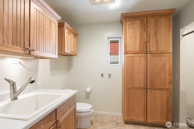 bathroom featuring vanity, baseboards, and toilet