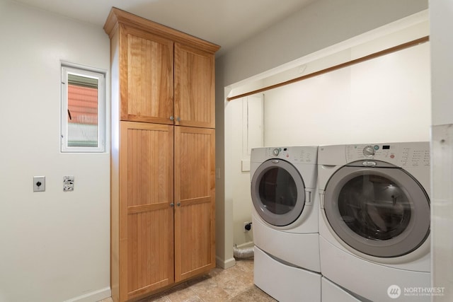 laundry area featuring separate washer and dryer, baseboards, and cabinet space