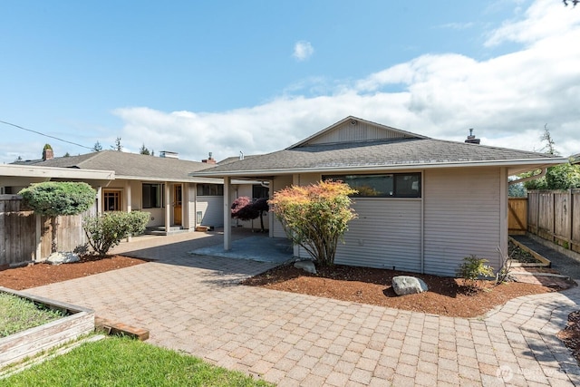 ranch-style home featuring fence