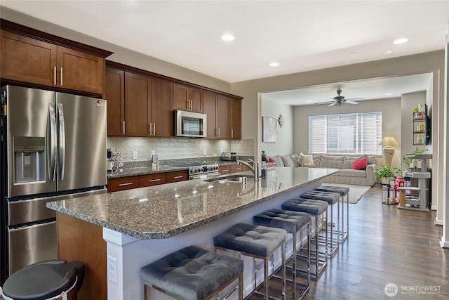 13146 83rd Ln S, Seattle, WA 98178 - kitchen featuring dark wood-style flooring, open floor plan, a kitchen bar, a sink, and appliances with stainless steel finishes