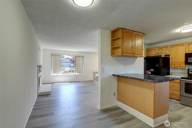 1917 E 60th St, Tacoma, WA 98404 - kitchen with a textured ceiling, open shelves, black appliances, a peninsula, and light wood-style flooring