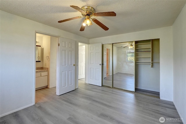 1917 E 60th St, Tacoma, WA 98404 - unfurnished bedroom with a ceiling fan, a textured ceiling, wood finished floors, baseboards, and a closet