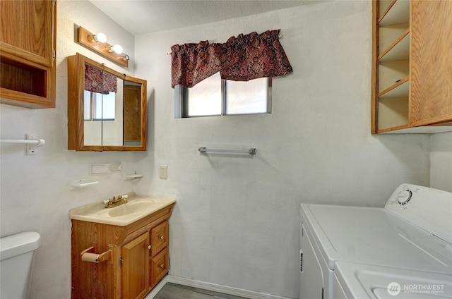1917 E 60th St, Tacoma, WA 98404 - bathroom with vanity, plenty of natural light, toilet, and washer and clothes dryer
