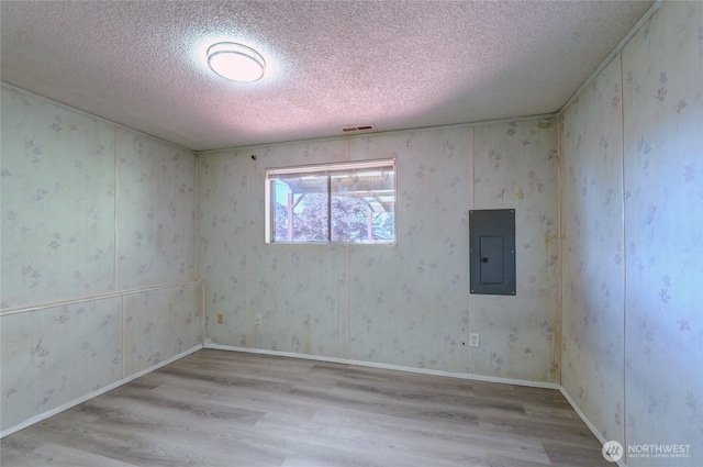 1917 E 60th St, Tacoma, WA 98404 - unfurnished room with visible vents, a textured ceiling, wood finished floors, and electric panel