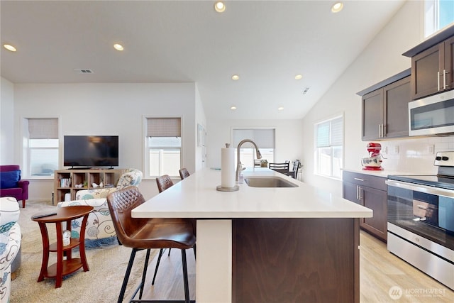 3 Gregory St, Milton-Freewater, OR 97862 - kitchen featuring appliances with stainless steel finishes, a sink, light countertops, a breakfast bar, and light wood-type flooring