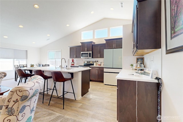 3 Gregory St, Milton-Freewater, OR 97862 - kitchen featuring appliances with stainless steel finishes, light wood finished floors, a kitchen breakfast bar, light countertops, and high vaulted ceiling