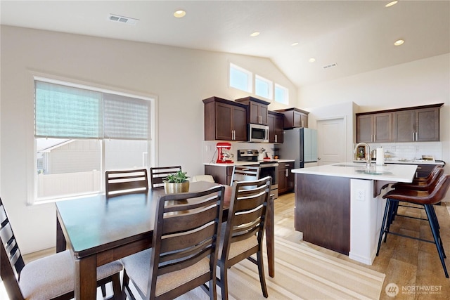 3 Gregory St, Milton-Freewater, OR 97862 - kitchen featuring stainless steel appliances, light countertops, dark brown cabinetry, decorative backsplash, and a center island with sink