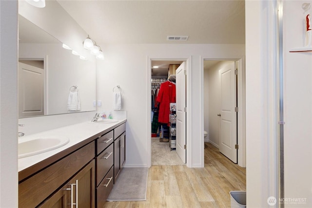 3 Gregory St, Milton-Freewater, OR 97862 - full bath with wood finished floors, double vanity, toilet, a walk in closet, and baseboards
