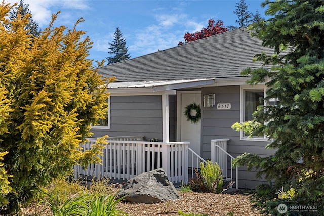 property entrance with roof with shingles