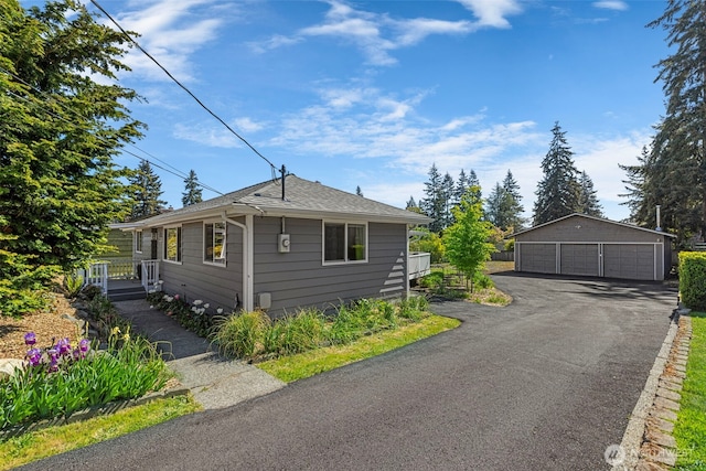 view of side of home with a garage, an outdoor structure, and a shingled roof