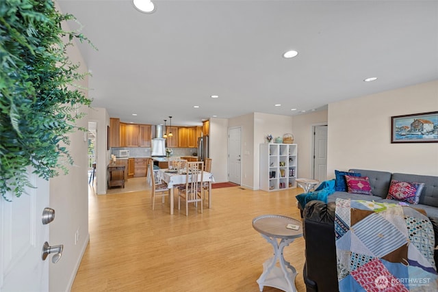 living room with recessed lighting, light wood-type flooring, and baseboards