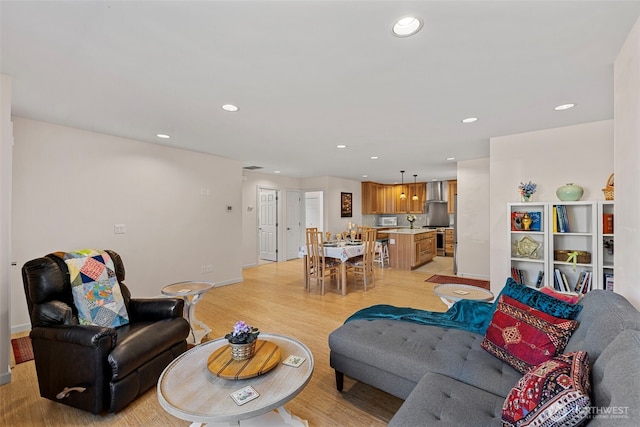 living room featuring recessed lighting, light wood finished floors, and baseboards