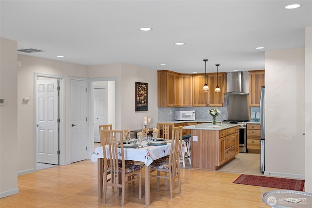 dining area featuring light wood-style flooring, recessed lighting, and baseboards