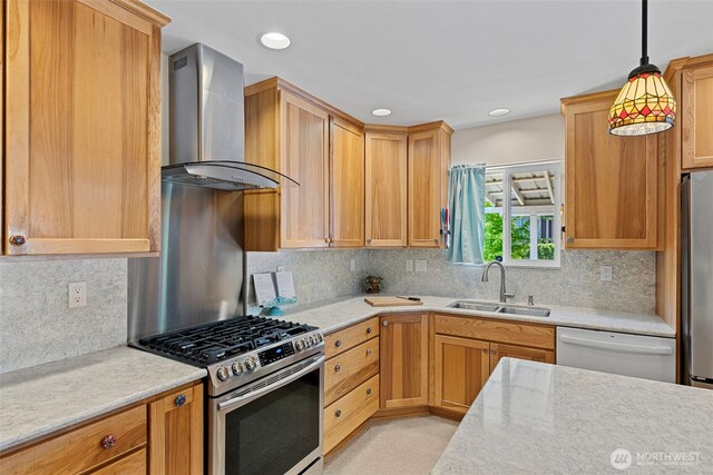 kitchen featuring wall chimney range hood, a sink, stainless steel appliances, decorative backsplash, and recessed lighting