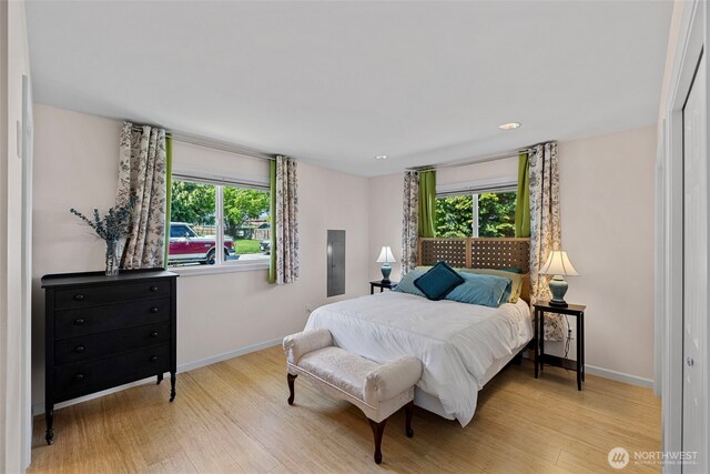 bedroom featuring multiple windows, wood finished floors, baseboards, and recessed lighting