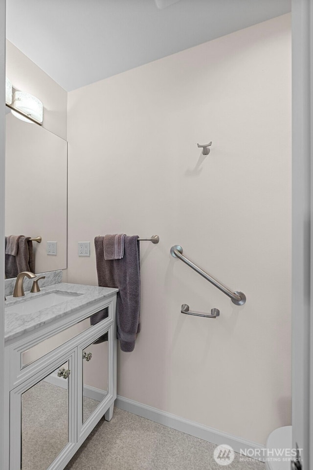 half bathroom with vanity and baseboards