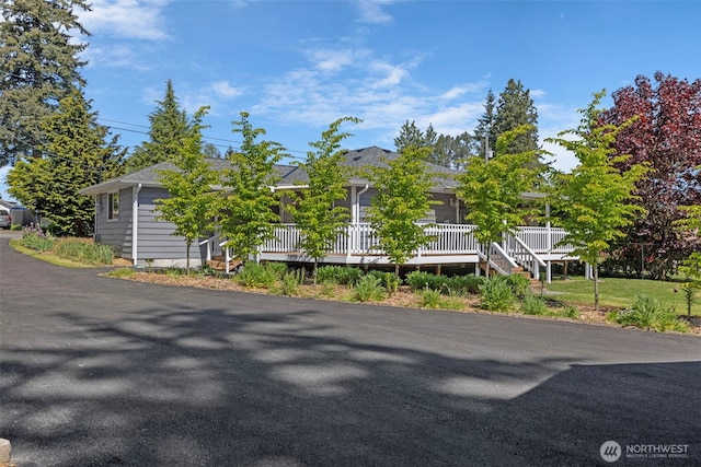 view of property hidden behind natural elements with a porch