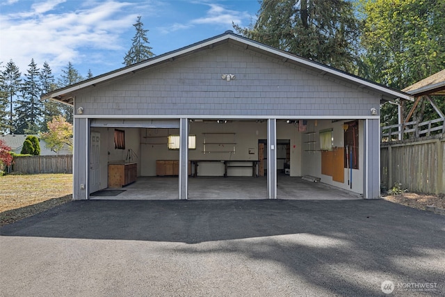 detached garage featuring fence