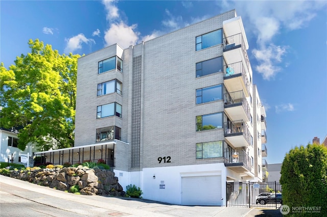 912 3rd Ave W Unit 303, Seattle, WA 98119 - view of property featuring an attached garage and fence