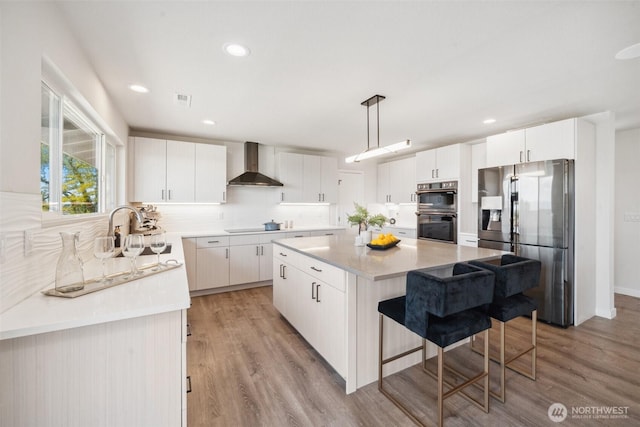 6409 NW 202nd Cir, Ridgefield, WA 98642 - kitchen featuring stainless steel appliances, wall chimney exhaust hood, a center island, tasteful backsplash, and recessed lighting
